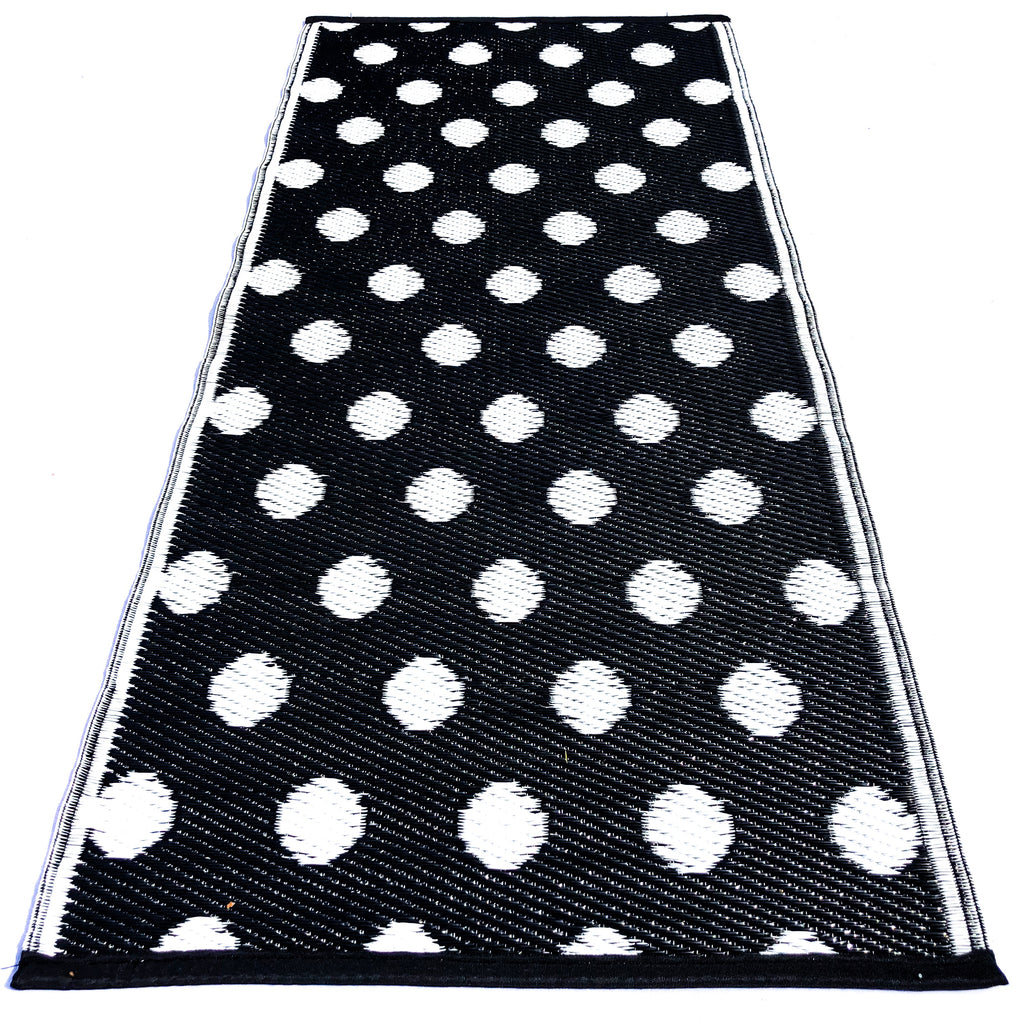Plastik tæppe i sort hvid. Prikker eller bolde i mønsteret. Et designer plastiktæppe fra Rastablanche. Populært..