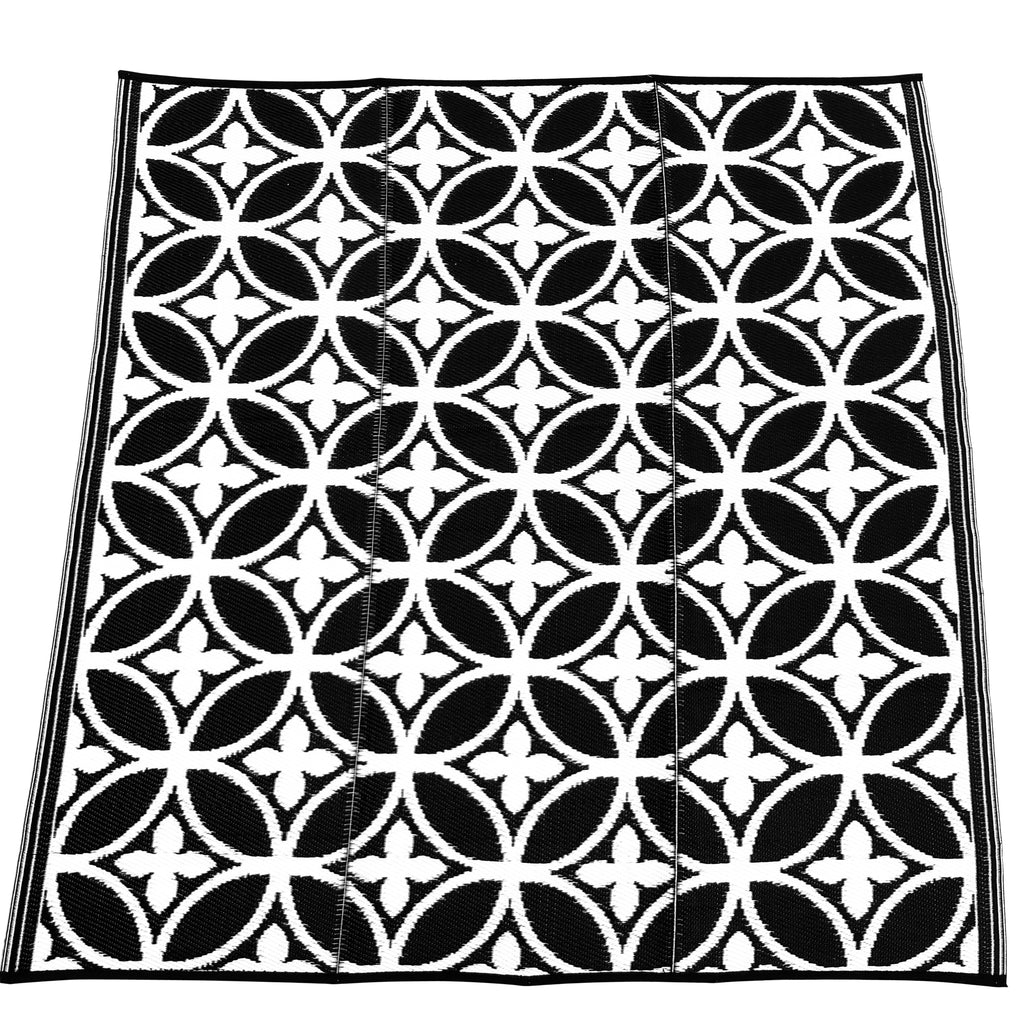 Plastik tæppe i sort hvid. Kvadratisk. Cirkler og liljer i mønster. Et designer plastiktæppe fra Rastablanche.  